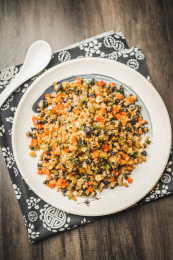 暗色木纹桌面上放着一份小炒稻香螺