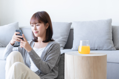 年轻女性靠坐在沙发边看手机