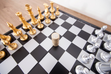 国际象棋棋盘上摆好的双方棋子和中间准备被争夺的欧元硬币