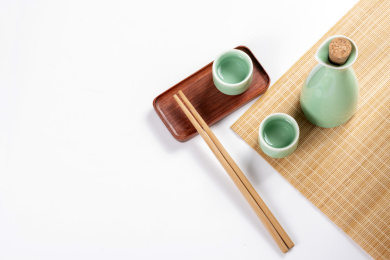 梅子青酒壶酒杯摆放在红色洒金背景上旁边放有中国结木托盘