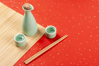 梅子青酒壶酒杯摆放在红色洒金背景上旁边放有中国结木托盘
