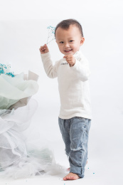 在花束旁边的可爱的两岁小男孩