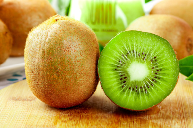 木底上放着绿心猕猴桃和猕猴桃切面