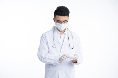 一位亚洲的年轻男医生正在戴一次性手套