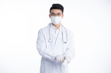 一位亚洲的年轻男医生正在戴一次性手套