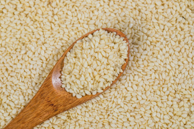 平铺的白芝麻上有一把盛有白芝麻的木勺