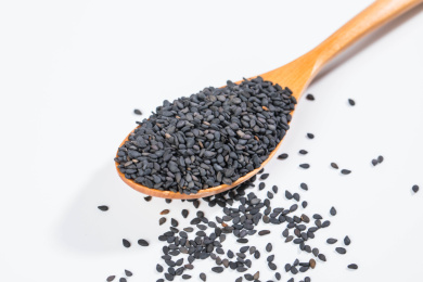 用木勺盛着的黑芝麻放在白色背景上