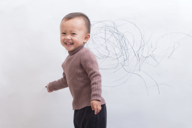 天真可爱的孩童在白墙上涂鸦