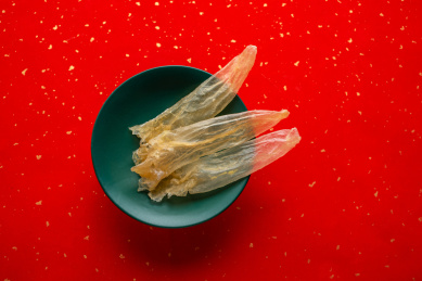 红色背景上一盘金黄色的花胶鳘鱼胶