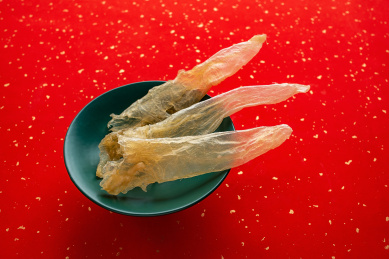 红色背景上一盘金黄色的花胶鳘鱼胶