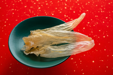 红色背景上一盘金黄色的花胶鳘鱼胶