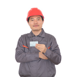 头戴红色安全帽手拿回家过年火车票的农民工
