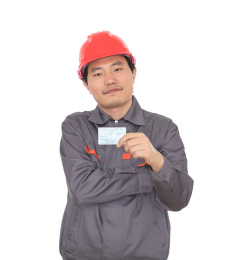 头戴红色安全帽手拿回家过年火车票的农民工