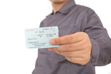 身穿工作服的工人展示抢到回家过年的火车票
