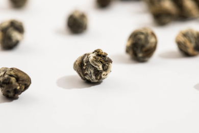 几颗洒落在白色背景上的茉莉龙珠