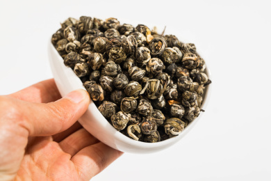 手拿着装有茉莉龙珠的白瓷茶荷