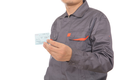 穿着工作服手拿过年回家火车票的民工