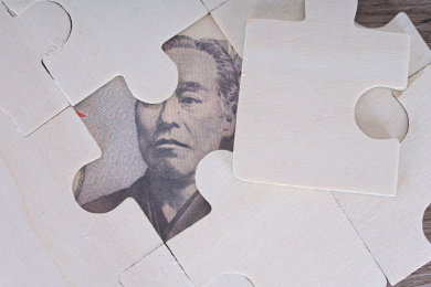 桌子上拼图游戏露出的日元钞票