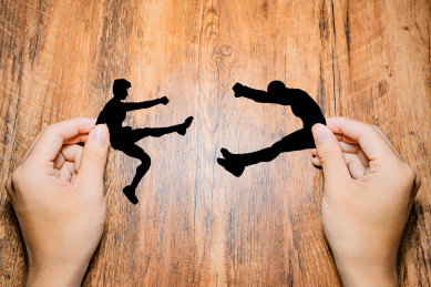 手拿着互相打架的小人幕后黑手概念