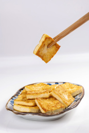 女性手持筷子夹起炸豆腐煎豆腐特写