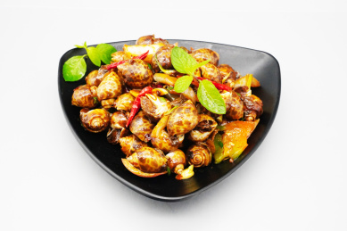 装在黑色盘子里的美食香辣花螺