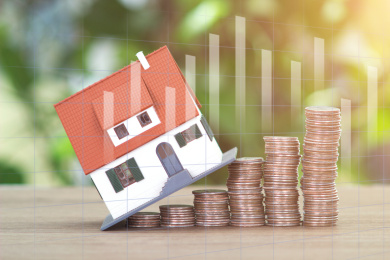 上涨的美元硬币和小房子模型组成的房地产投资概念