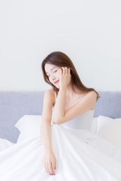 早上睡醒坐在床上的年轻女孩