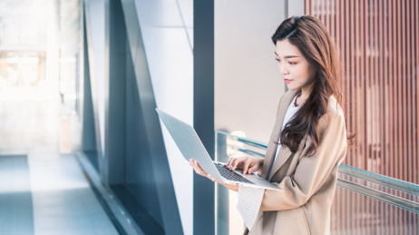 年轻亚洲商务人士在走廊看电脑