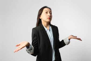 身穿正装的女人站在白色背景墙前全身人像