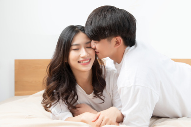  穿着白色短袖趴在床上的一对亚洲年轻情侣