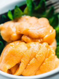 摆在盘子里的新鲜海胆和装饰叶子