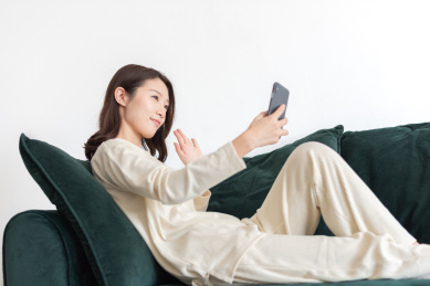 年轻女士坐在沙发上使用手机