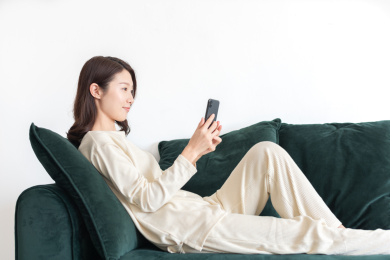 年轻女士坐在沙发上使用手机