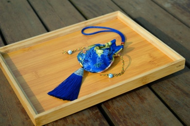 放在原木色盘子里的深蓝色刺绣锦囊