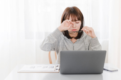 短发女生疲倦的摘掉眼镜揉眼睛