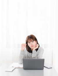 短发女生坐在桌子边思考问题