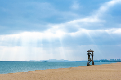 海滩上的瞭望塔与海面上的丁达尔光