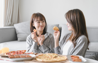 闺蜜一起坐在茶几手拿披萨