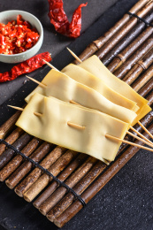一份新鲜涮串干豆腐串放在竹帘上