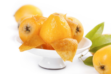 白底上放着一盘枇杷和枇杷果肉