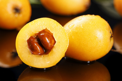 黑底上放着枇杷和枇杷果肉