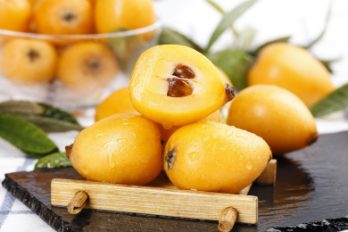 黑底上放着一堆枇杷和枇杷果肉