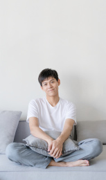 男生一个人坐沙发上微笑