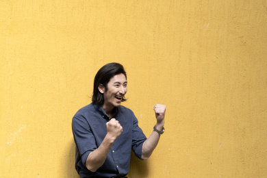 站在黄色背景前的年轻商务男士