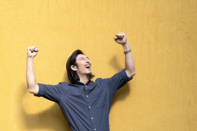 站在黄色背景前的年轻商务男士