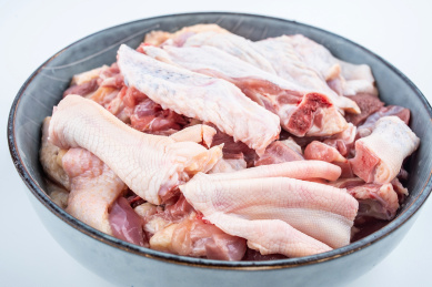 白背景上一碟新鲜剁块的鸭肉