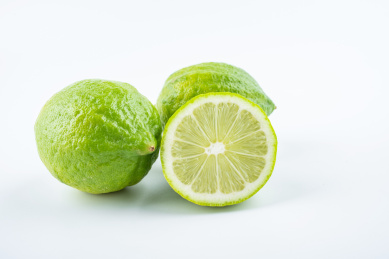 白背景上一碟新鲜青柠檬和果肉切片