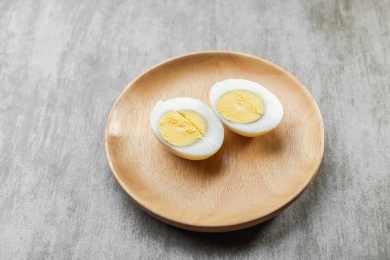 浅色木纹桌面上放着一盘切开煮鸡蛋