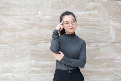 都市女青年在大理石墙前单手扶额思考