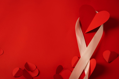 情人节红色背景上的一些红色爱心剪纸和丝带